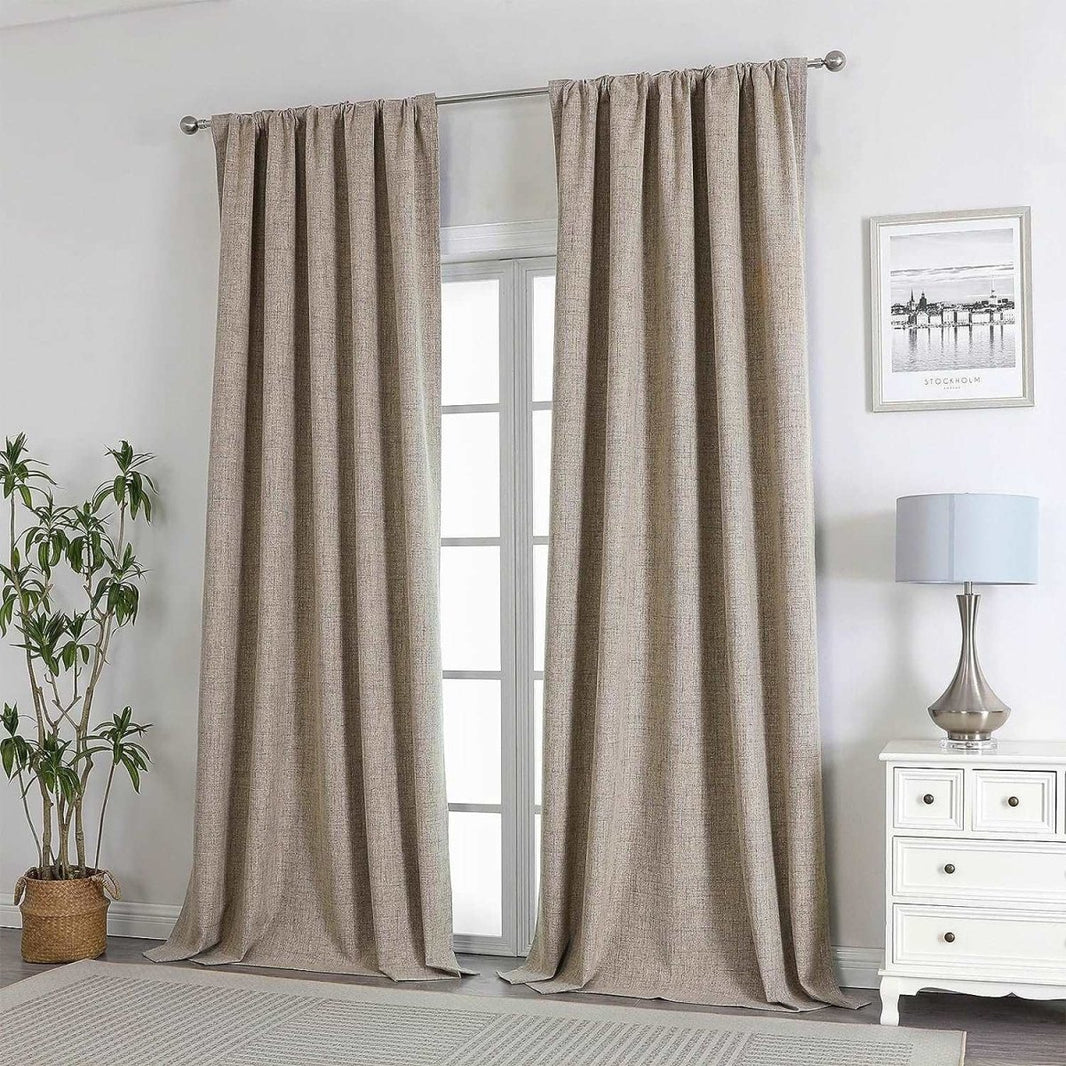 Joydeco beige linen blackout curtains with textured weave, shown in a living room setting with a plant and nightstand.
