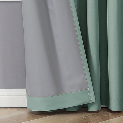 Mineral blue 100% blackout curtains with grey lining and smooth fabric folds, on a wooden floor.