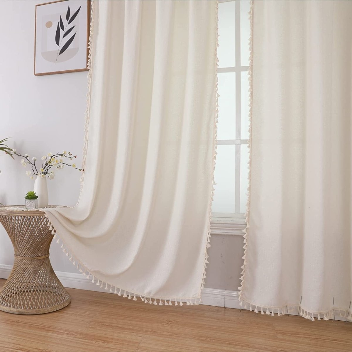 Creamy beige boho linen curtains with tassel trim, semi-sheer fabric creating soft ambiance for living room.