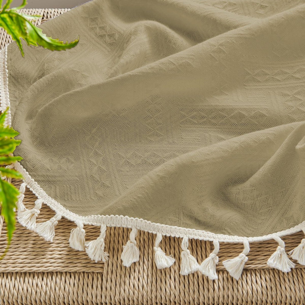 Khaki linen sheer curtain fabric texture with diamond pattern, white trim, and cream boho tassels.