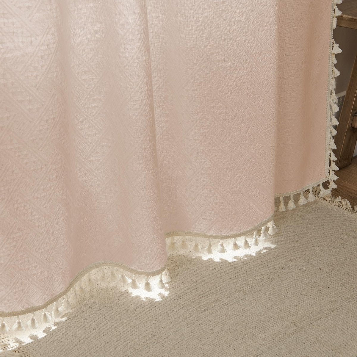 Joydeco boho pink linen sheer curtain with diamond pattern and cream tassel fringe on living room floor.