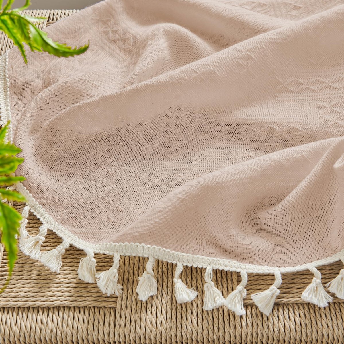 Close up of Joydeco boho pink linen sheer curtain with diamond pattern and cream tassel trim.