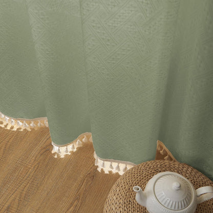 Sage green linen sheer curtain close-up, diamond weave texture, cream tassels, boho farmhouse style.