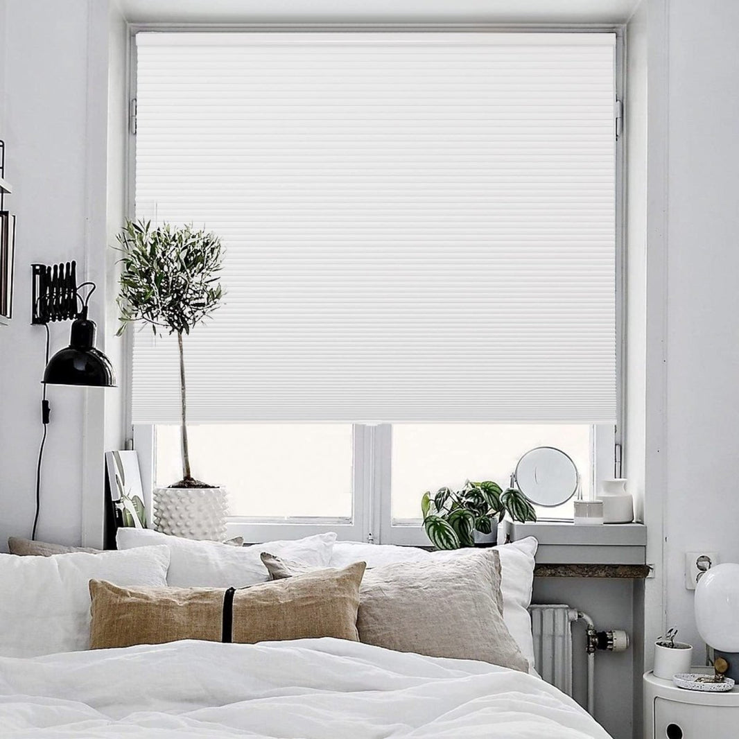 Joydeco cordless white blackout cellular shades with honeycomb design covering a bedroom window.