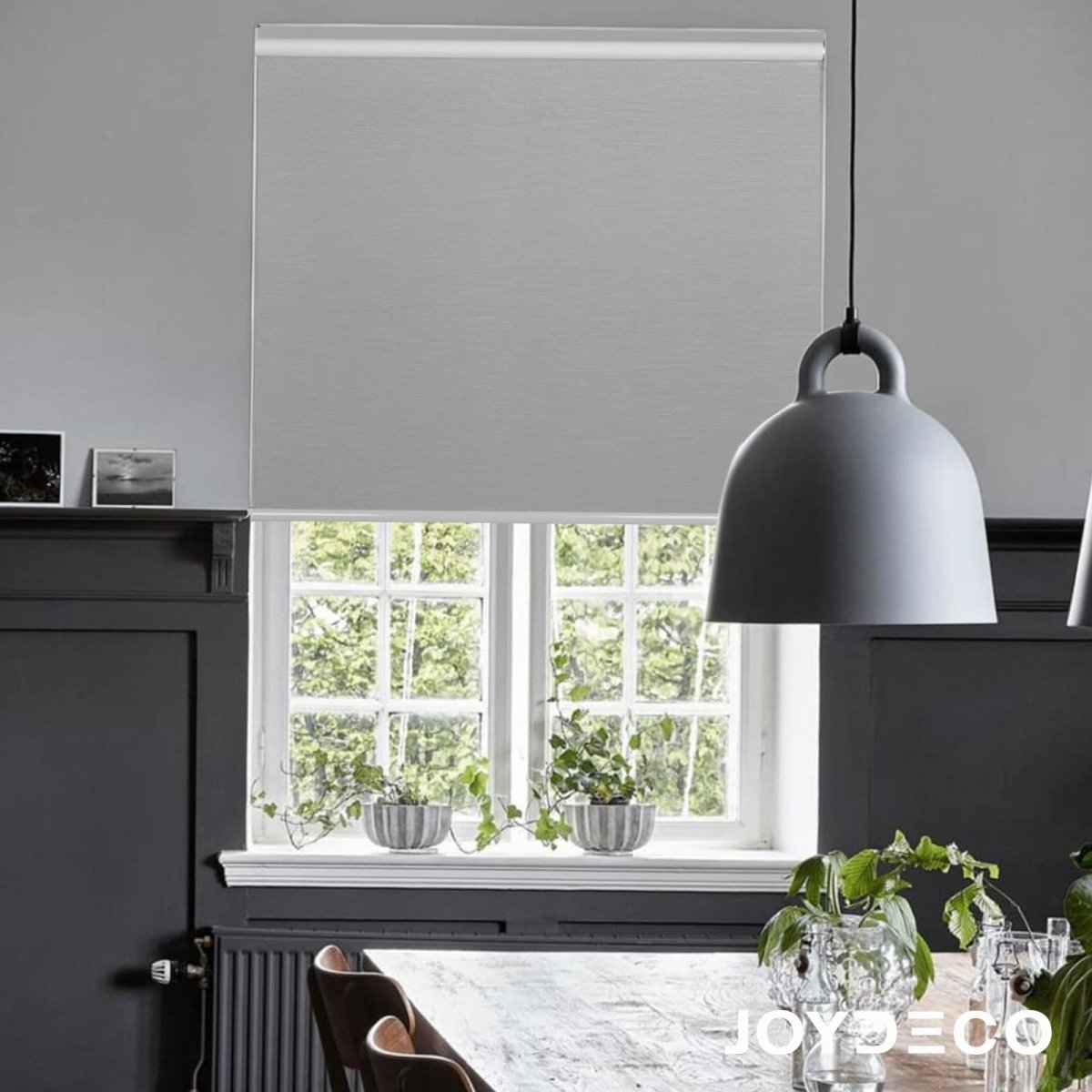 Light grey Joydeco 100% blackout roller shade with subtle jacquard pattern, enhancing modern dining room ambiance.