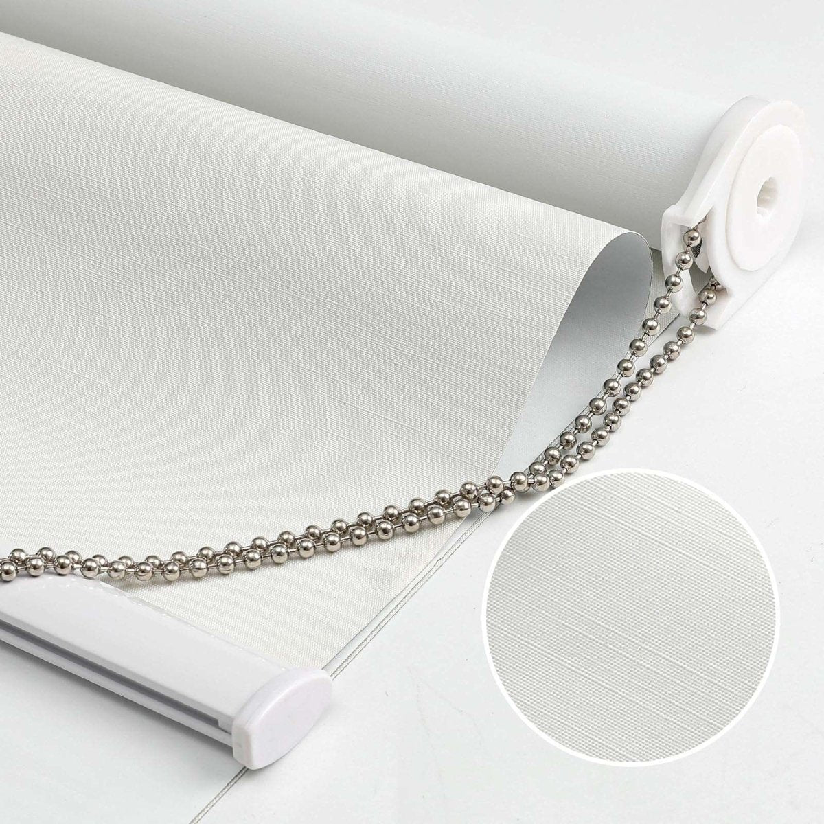 White 100% blackout roller shade with subtly textured fabric, metal pull chain, and close-up fabric detail inset.