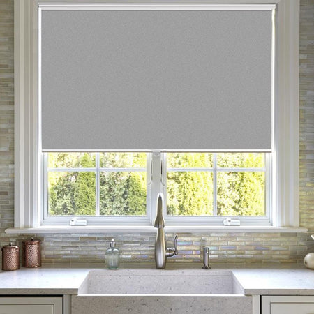 Joydeco light gray cordless blackout roller shade on kitchen window with aluminum bottom rod.