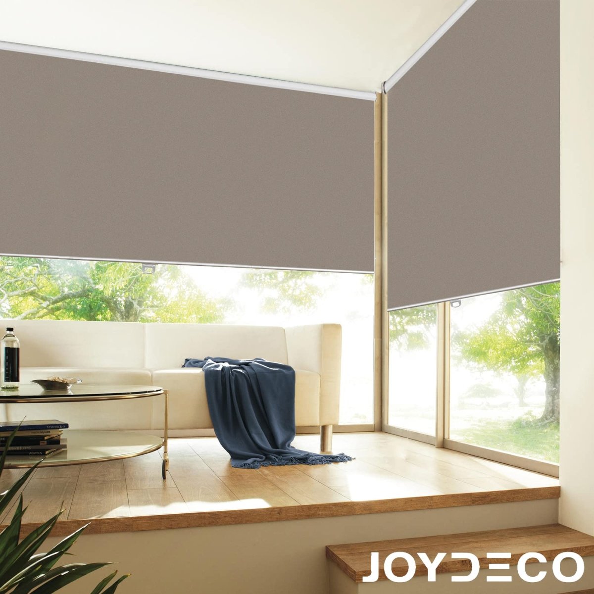 Joydeco taupe blackout roller shades partially lowered in a modern living room, enhancing ambiance and privacy.