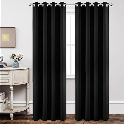 Joydeco Custom Basic Blackout Curtains: two floor-length solid black grommet top curtains hanging in a room setting.