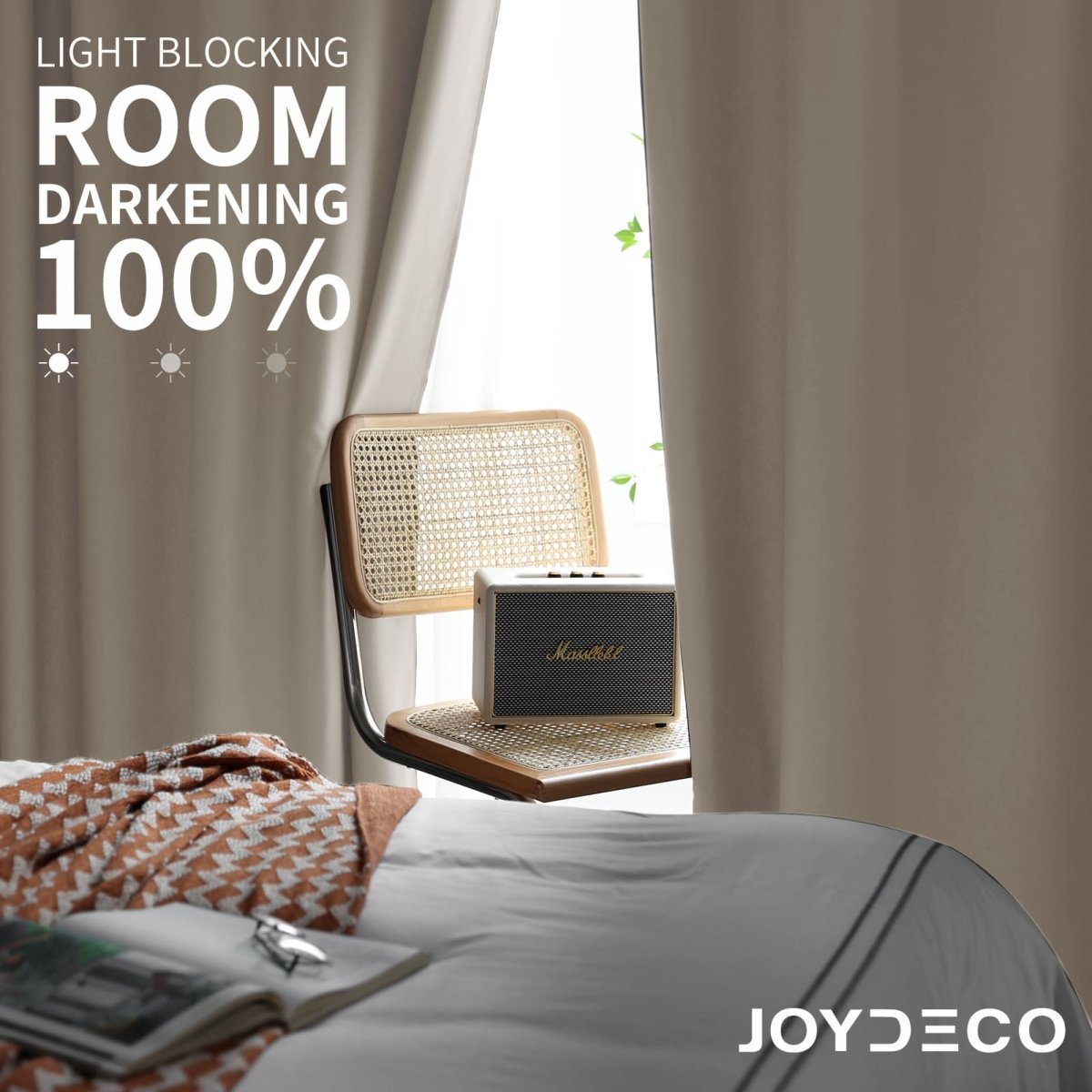 Joydeco beige blackout curtains in bedroom, 100% light blocking, heavy fabric, with woven chair and speaker.