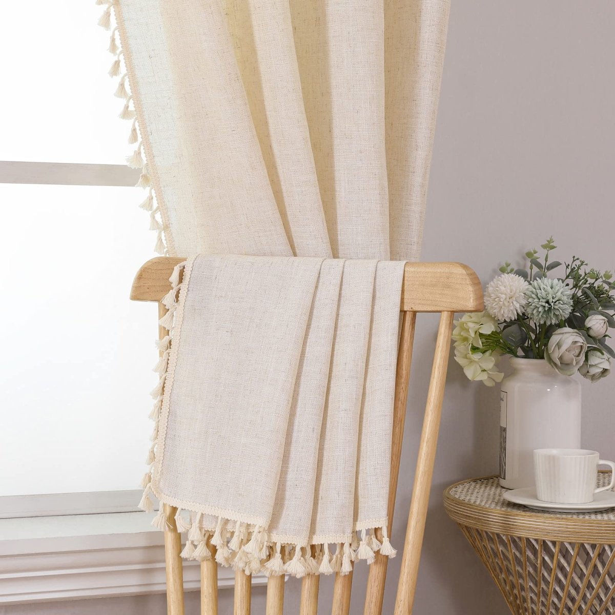 Cream boho linen curtains, 108 inches, with tassels and woven texture, draped on a chair for living room decor.
