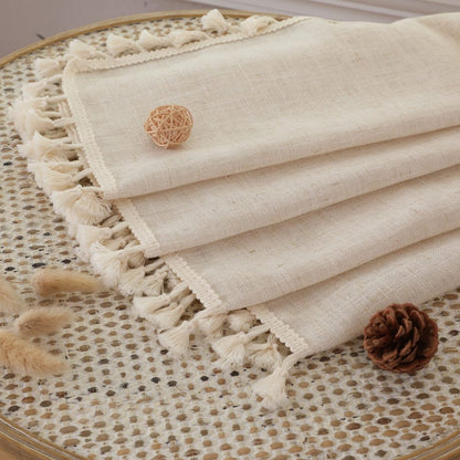 Close-up of cream boho linen curtains with textured weave and tassel trim, showcasing fabric detail for living room.