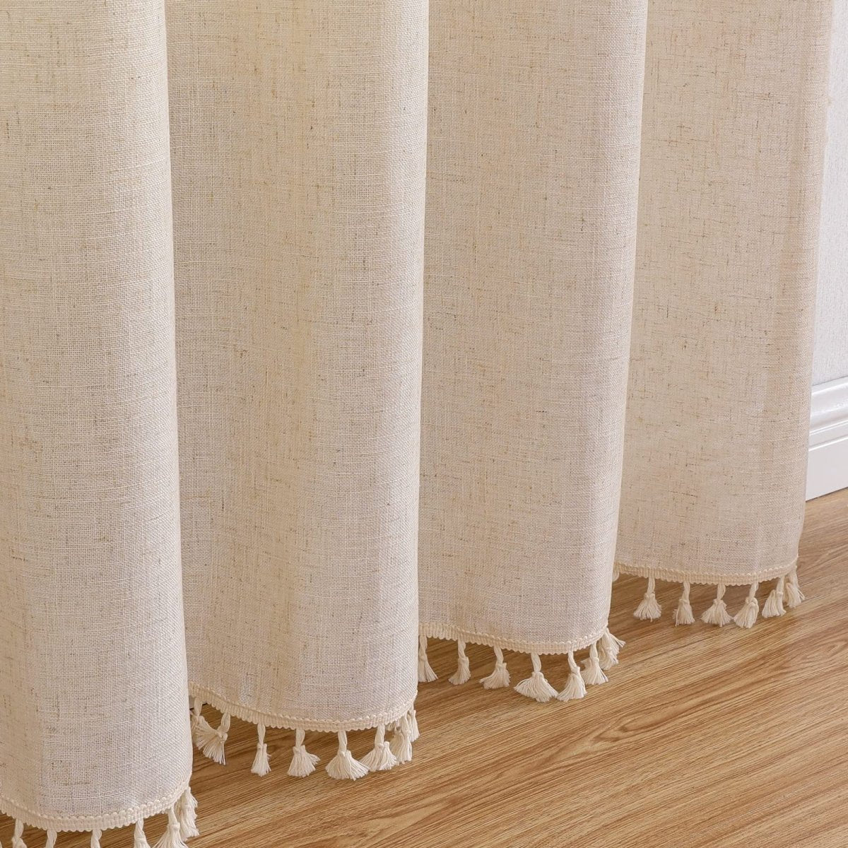 Close up of cream boho linen curtains with tassel trim, showcasing textured weave. 108 inch long.