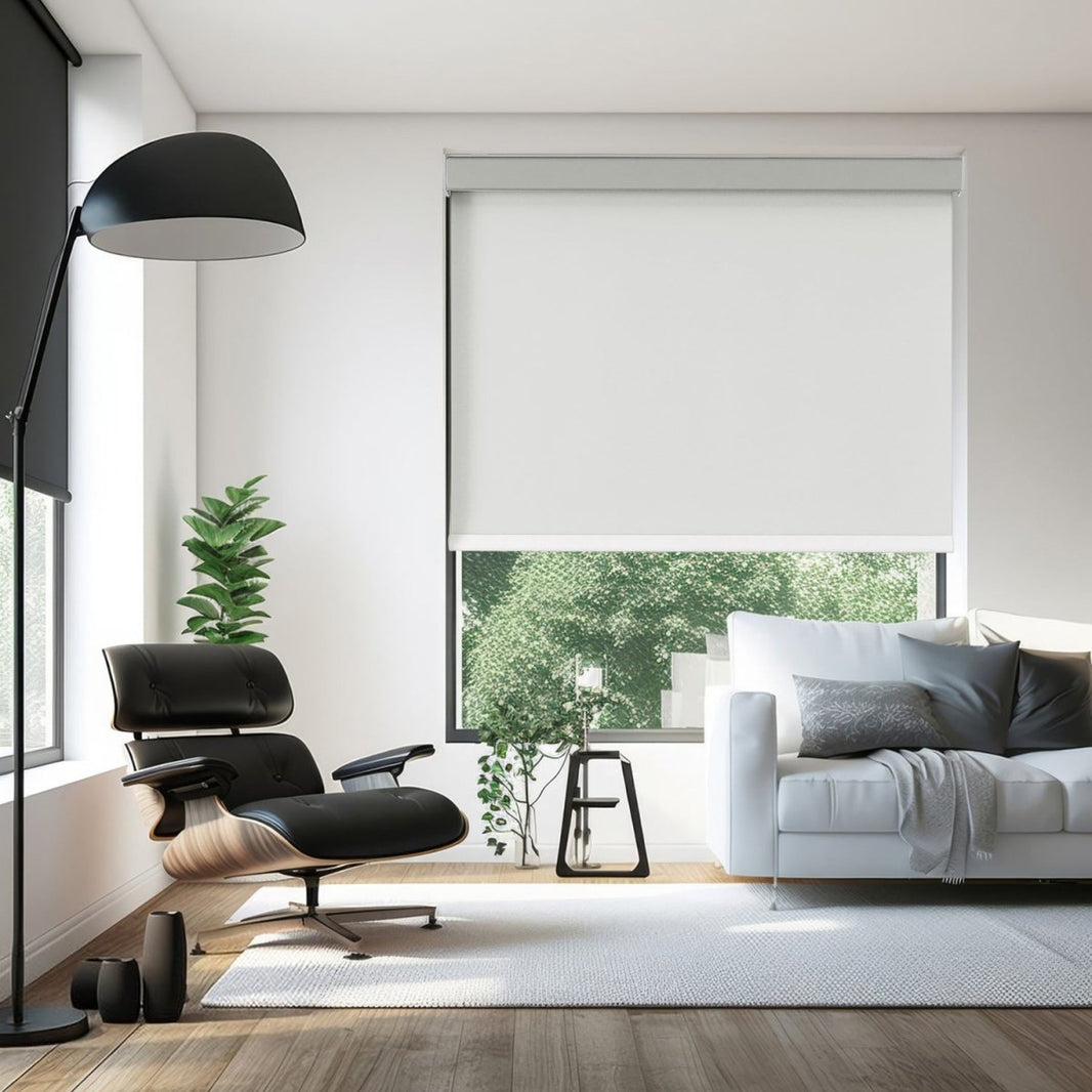 Joydeco modern blackout roller shade in white, enhancing a living room with a black Eames chair and white sofa.