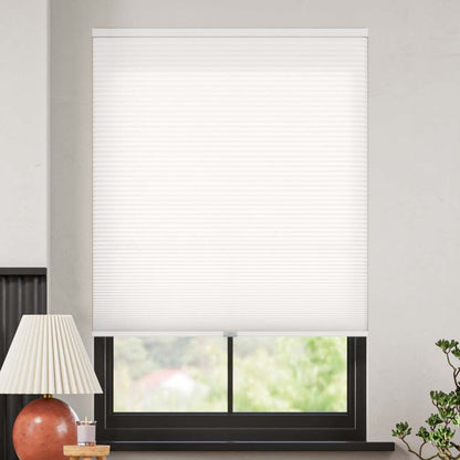 White cordless light filtering cellular shade with honeycomb texture, partially open on window.