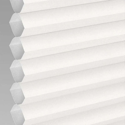 Close-up of white cordless cellular shade showing honeycomb texture and light filtering fabric, product appearance.