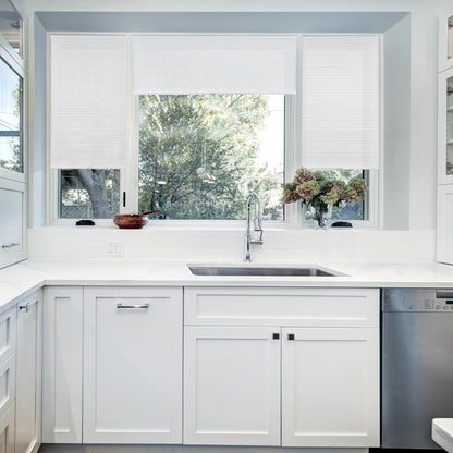 Joydeco white cordless cellular shades on kitchen window, light filtering honeycomb texture.