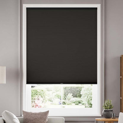 Joydeco black cordless blackout cellular shades with honeycomb texture installed on white window frame.