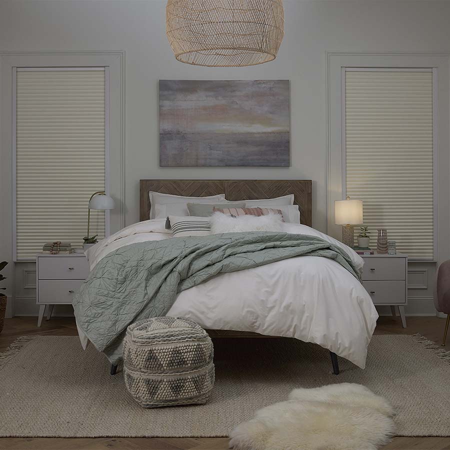 Cream cordless blackout cellular shades in a bedroom, showing product integration and light blocking feature.