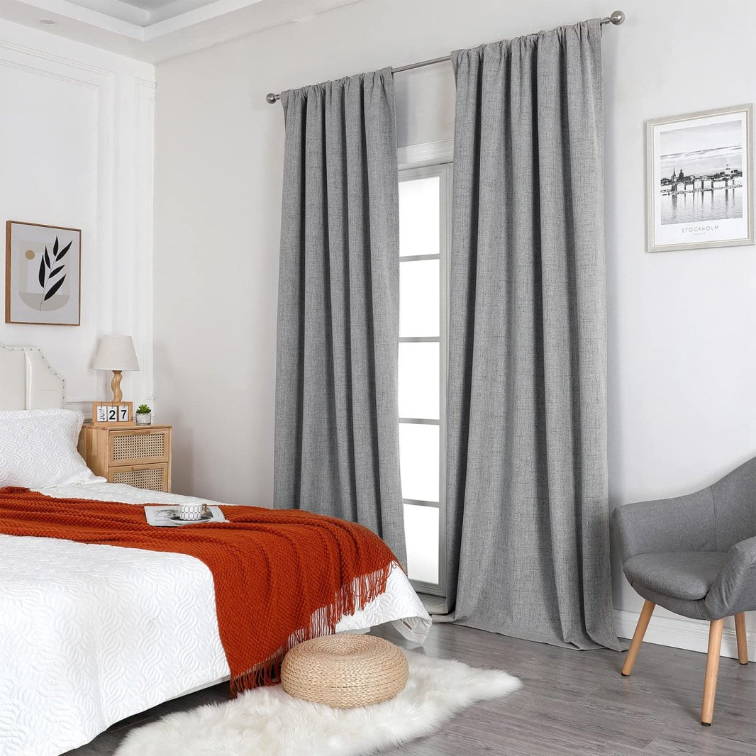 Grey linen blackout curtains with rod pocket style in a modern bedroom, showcasing room integration and product appearance.
