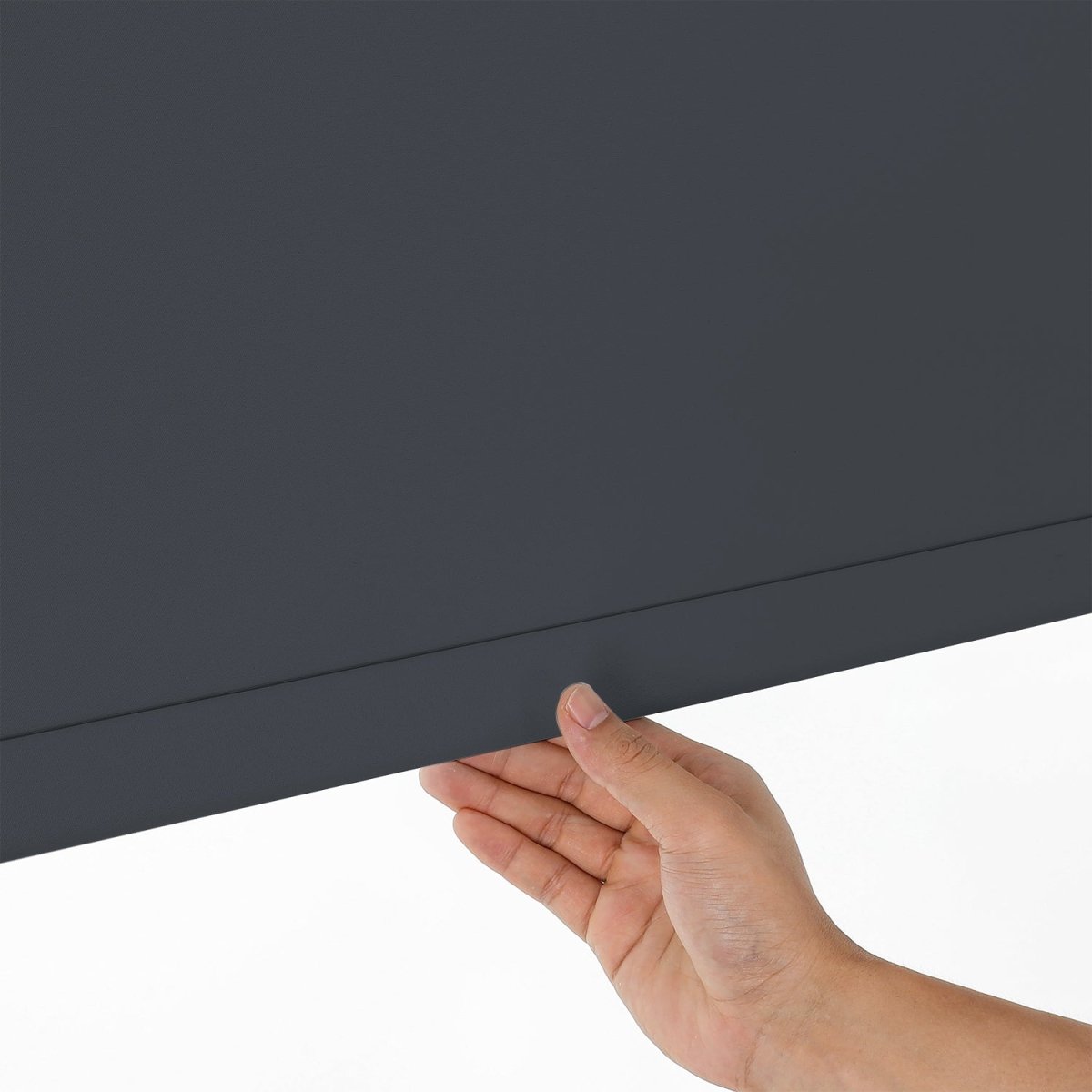 Hand demonstrating smooth pull-down operation of dark gray cordless blackout roller shade with aluminum rod.