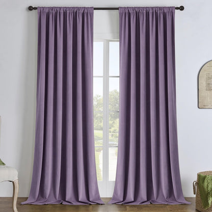 Two custom purple velvet blackout curtains with vertical pleats hanging floor to ceiling on a black rod.