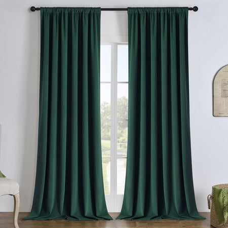 Hunter green linen blackout curtains hanging on a black rod, offering energy efficiency and privacy for any room.