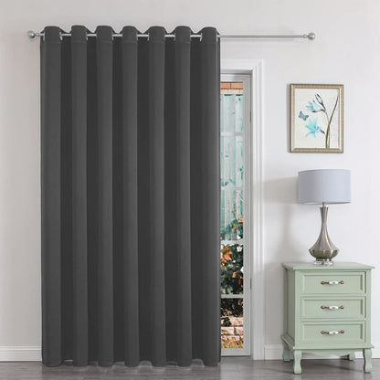 Dark grey blackout curtain with grommets hangs on a doorway, ideal for bedroom or closet doors.