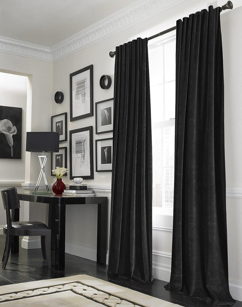 Joydeco black velvet blackout curtains with rod pocket in a stylish room with framed art and modern furniture.