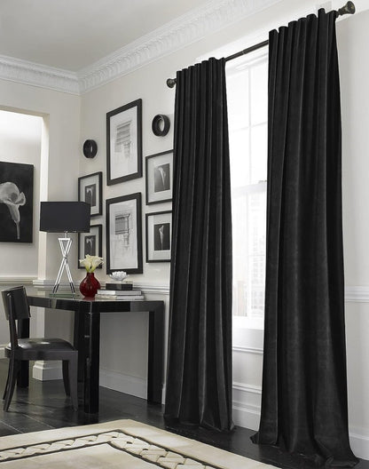 Joydeco black velvet blackout curtains with rod pocket in a stylish room with framed art and modern furniture.