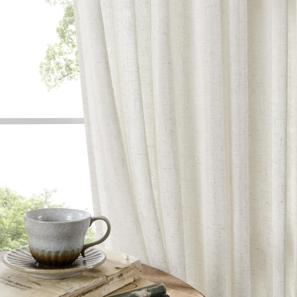 Off white linen sheer curtains in living room, filtering light, showcasing texture. Cozy atmosphere.