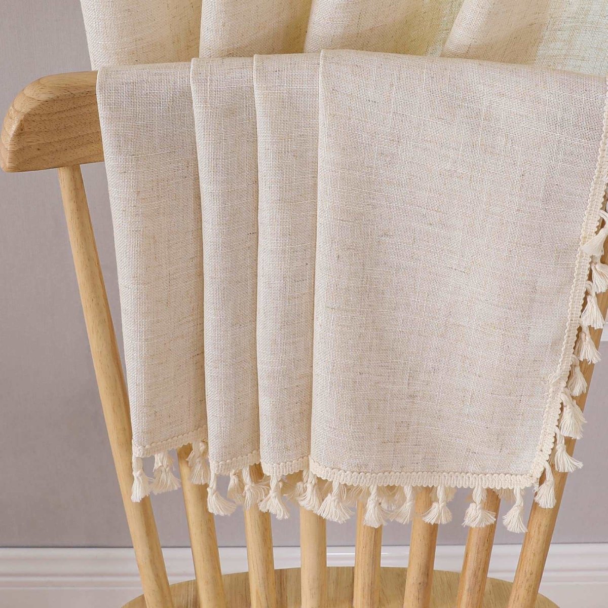 Close-up of Joydeco beige linen curtains featuring natural texture and tassel trim detail.
