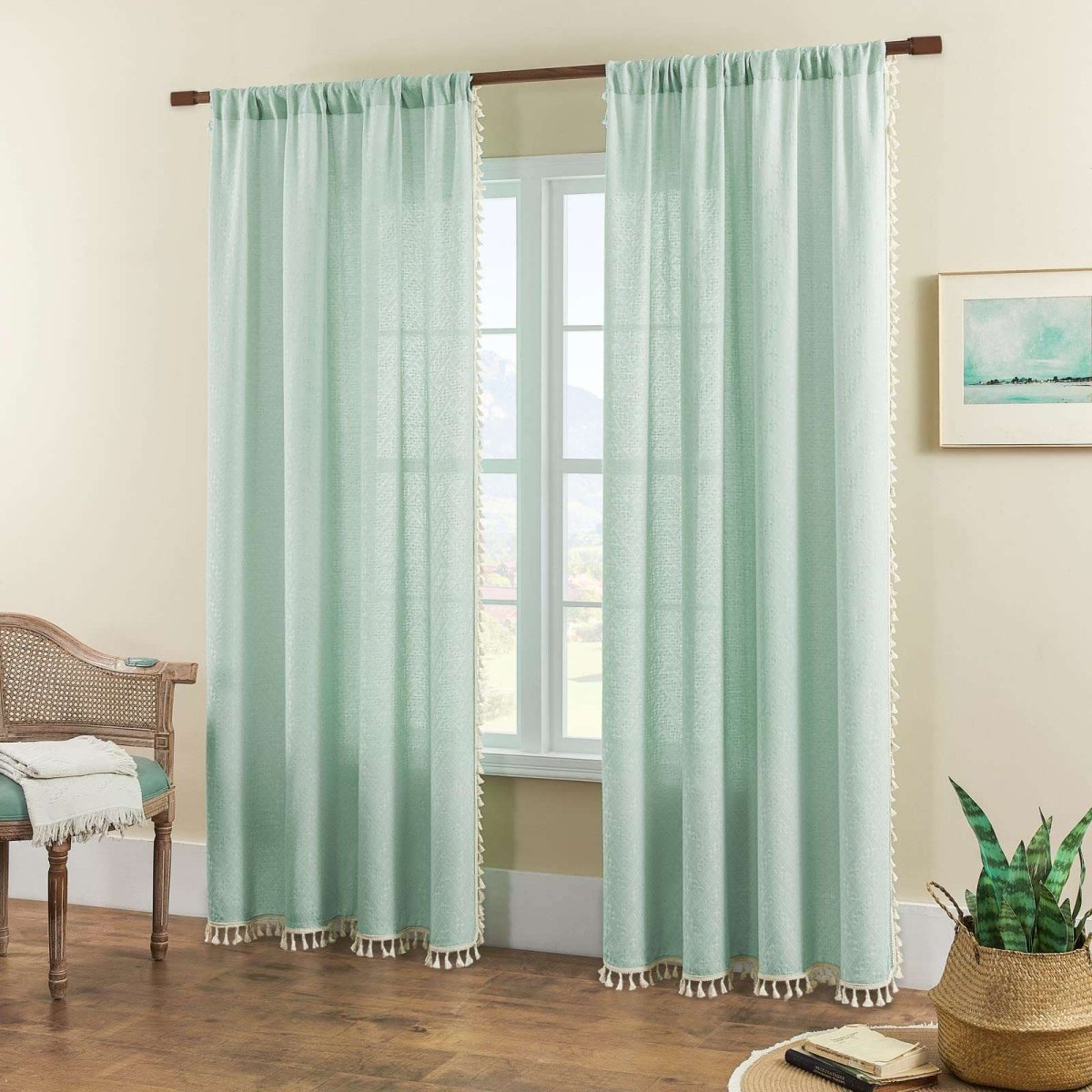 Joydeco mint green boho linen sheer curtains with tassels displayed on a rod in a room setting.