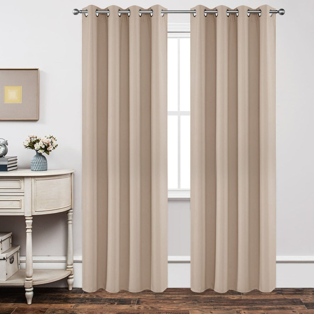 Joydeco beige textured blackout curtains with grommet tops hanging in a room with decor.