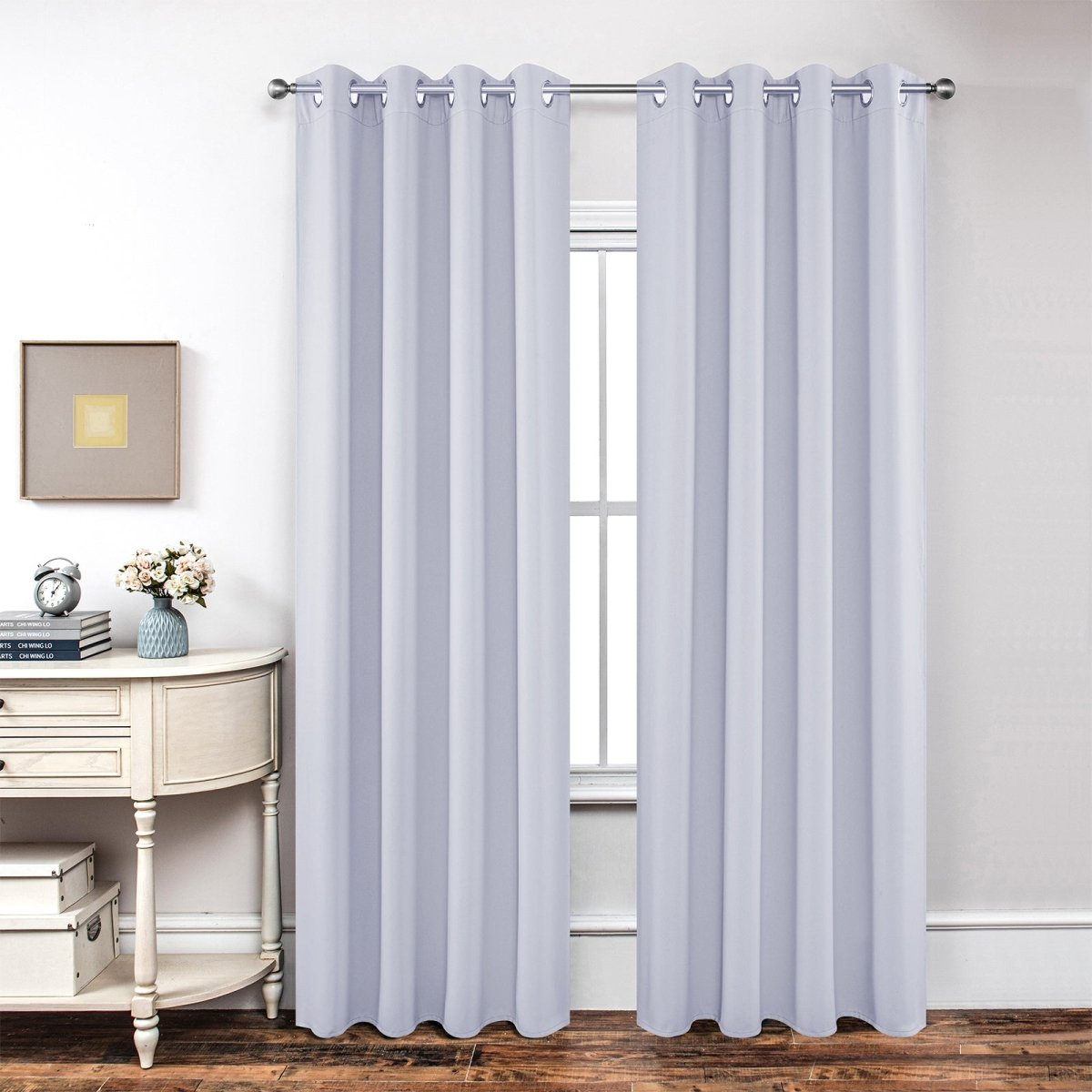 Joydeco light purple textured blackout curtains with grommet tops hanging in a room.