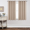 Joydeco beige grommet blackout curtains hanging in a room with a vintage table.