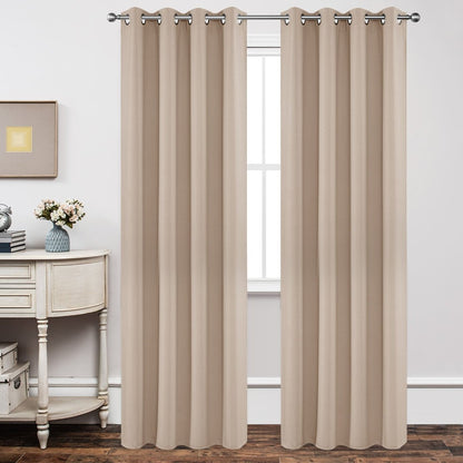 Light beige blackout curtains with grommets hang on a silver rod, showcasing smooth fabric texture on a bedroom window.