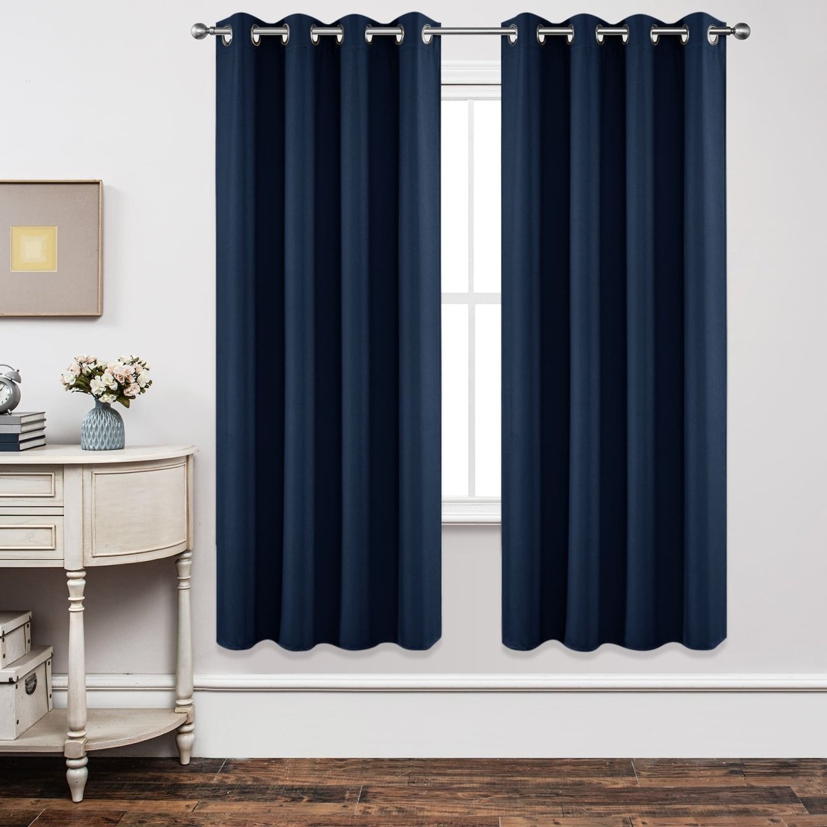Navy blue blackout curtains with grommets, shown in a bedroom setting for light blocking and thermal insulation.