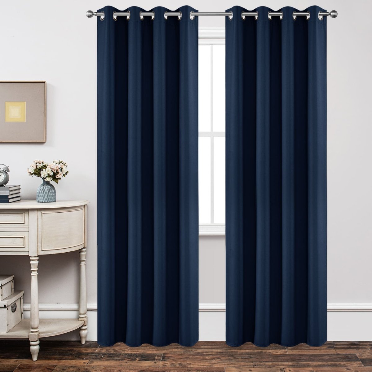 Navy blue blackout curtains with grommets displayed in a bedroom setting.