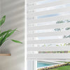 White dual layer sheer zebra blinds filtering light from a sunny backyard with a swimming pool.